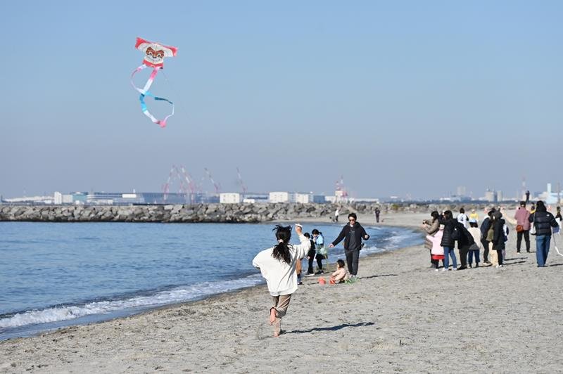 凧が揚がるように浜辺を走る子ども＝１０日、千葉市美浜区のいなげの浜
