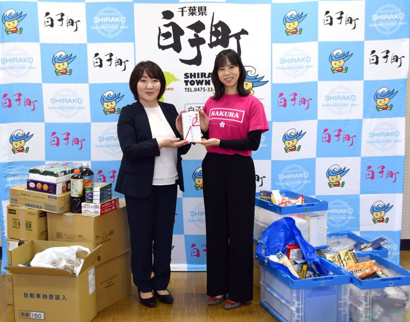 片岡代表（右）に食品などを贈る千葉マツダの鴇田さん＝白子町