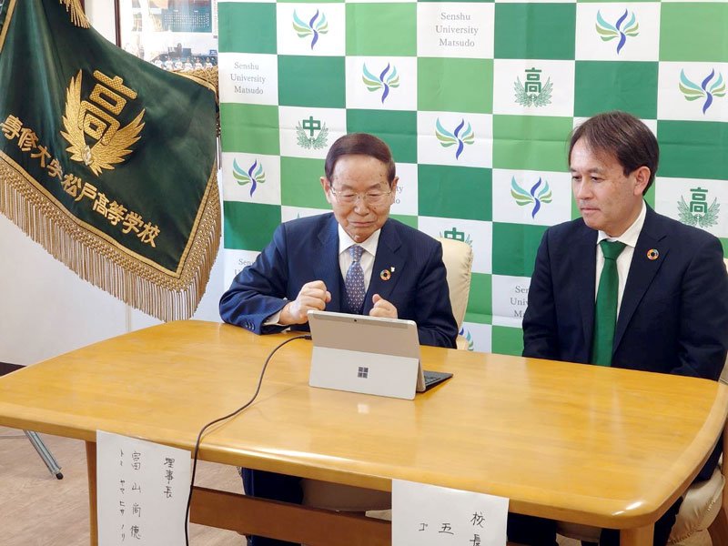 選抜高校野球出場が決まり、拳を握って喜ぶ富山尚徳理事長（左）