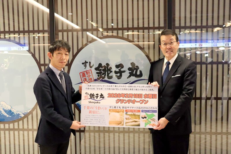 新店舗の前で看板を掲げる石井社長（右）ら＝東京都新宿区