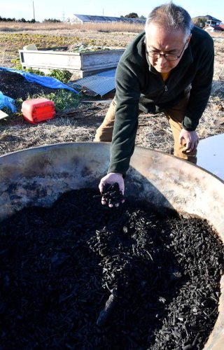 喜屋武さんがナシの剪定枝から作ったバイオ炭。農地にまきやすいよう手で粉々になるほど軟らかい仕上がりにしている