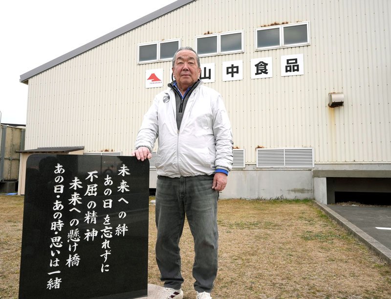 工場の隅に建てられた石碑と山中社長＝旭市萩園
