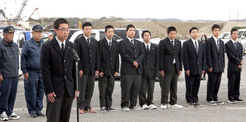 遠洋航海を終え、式典で実習報告をする小林さん（左）と生徒ら＝館山市