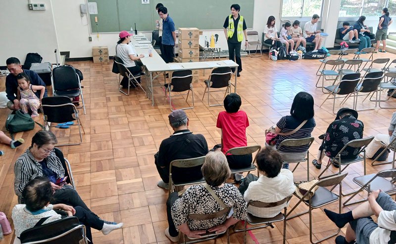 津波警報発令を受けて北条小学校に避難する地元住民と観光客ら＝昨年７月３０日、館山市