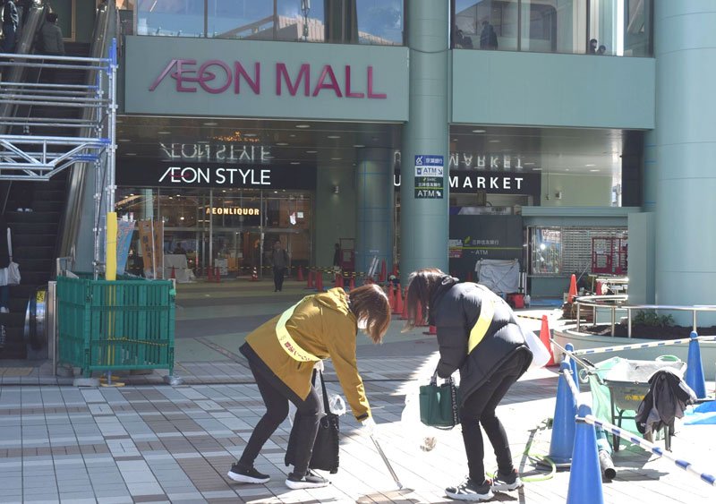 「イオンモール津田沼サウス」前でごみを拾う参加者＝１１日、習志野市