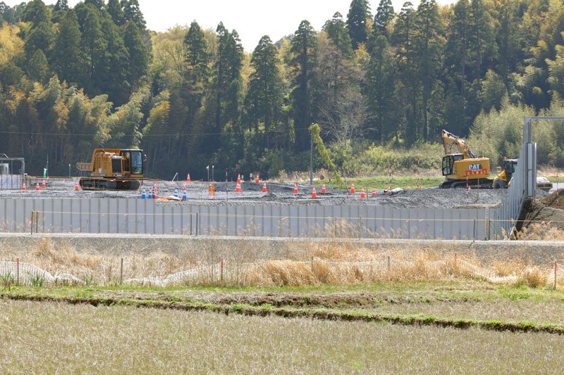 田んぼや林の中にフェンスで囲われた工事現場が整備された成田空港機能強化の用地＝３日、芝山町
