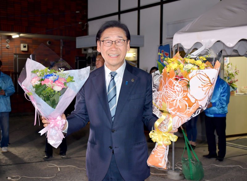 市長選に勝利し花束を掲げる田中氏＝１９日夜、市川市