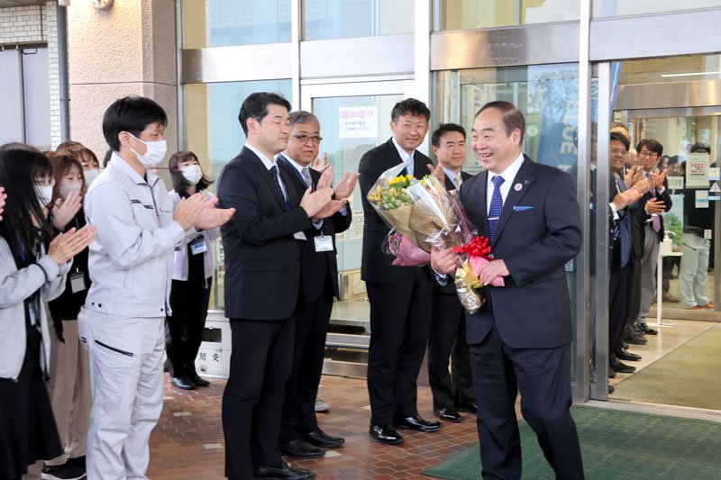 山武市役所を職員に見守られながら後にする松下氏＝２２日夕、山武市