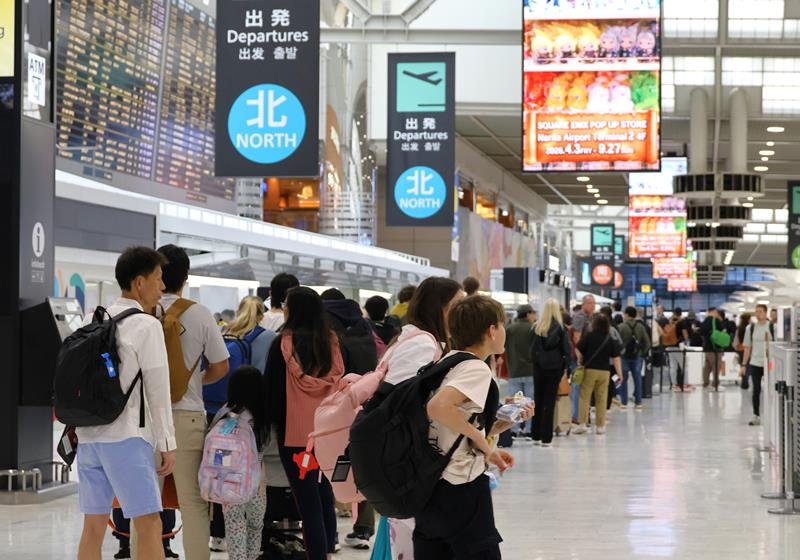 成田空港から出国するため保安検査場の列に並ぶ大勢の旅客＝２４日午後、成田市
