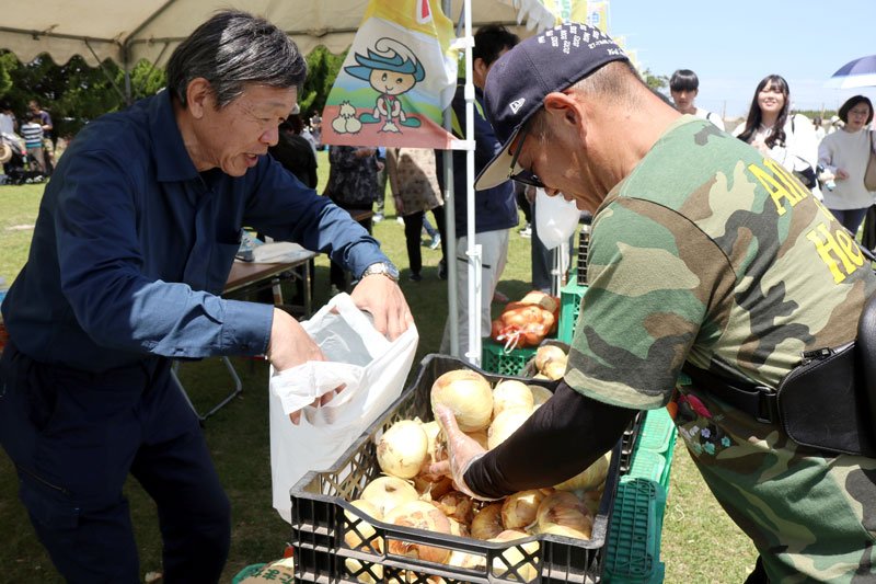 タマネギのつかみ取りに挑戦する男性（右）＝１０日、白子町