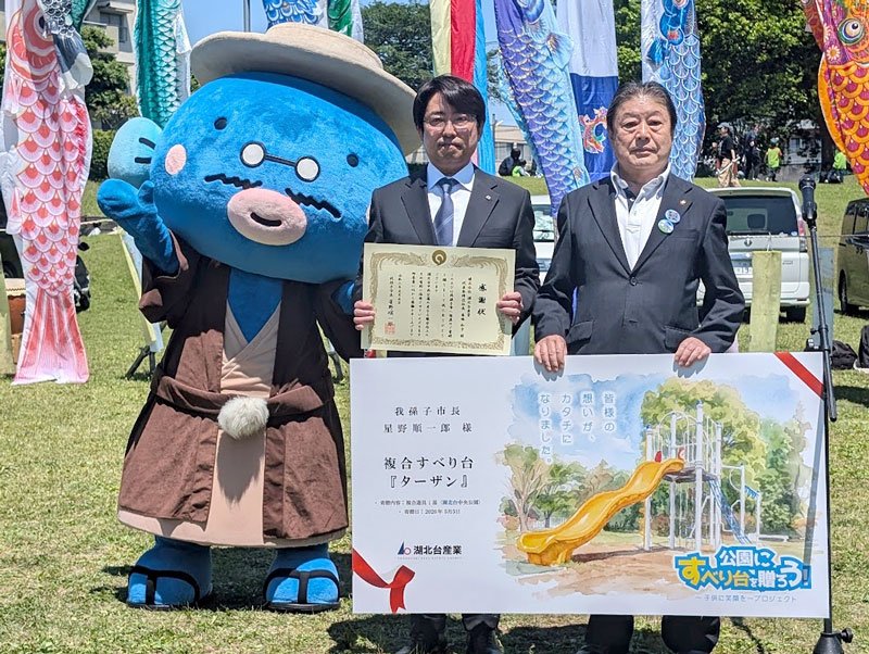 寄贈式で感謝状を手にする、湖北台産業の番場社長（左）と星野市長＝我孫子市の湖北台中央公園