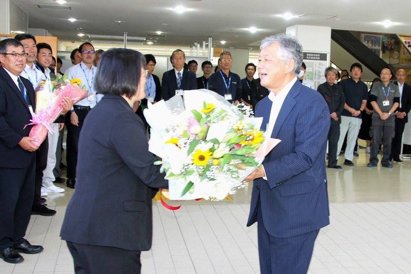 職員から花束を受け取り、市役所を後にする嶋田副市長（右）＝南房総市