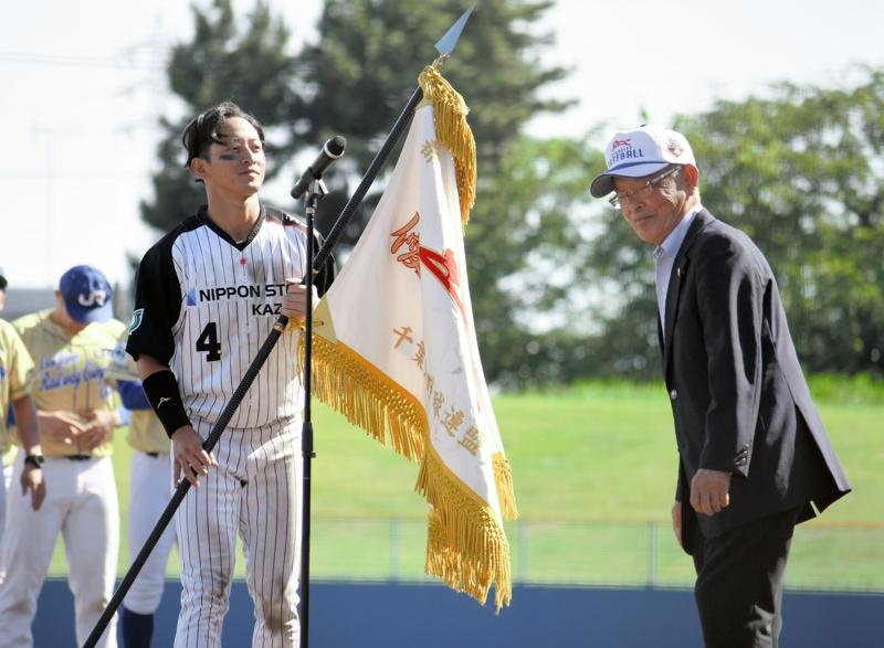決勝でＪＦＥ東日本を下し、優勝旗を受け取る日本製鉄かずさマジックの大内主将（左）＝３１日、千葉市の県総合スポーツセンター野球場