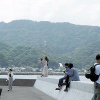 鋸山を望み、写真を撮りながら楽しむ若者たち＝３１日、富津市
