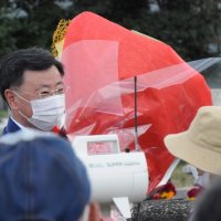 お祝いの花束を支持者から贈られる松野官房長官（左）＝１０日午後、市原市