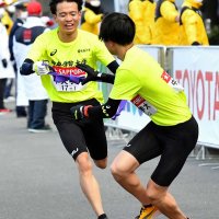 中央学院大２区の吉田礼志（右）にたすきを渡す１区の栗原啓吾＝横浜市鶴見区
