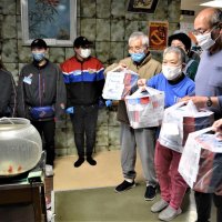 ピザを受け取り、配達スタッフ（左）に感謝する入居者ら＝船橋市の「福寿荘」
