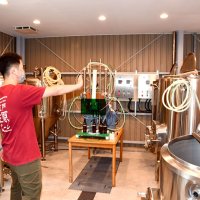 クラフトビールの醸造設備を説明する小林さん＝香取市