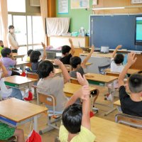 リモート始業式で電子黒板に映し出された校長の呼びかけに答える児童たち＝１日午前、長生村立高根小学校