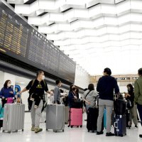 訪日個人旅行が解禁され、外国人が行き交う成田空港の国際線到着ロビー＝１０月１１日