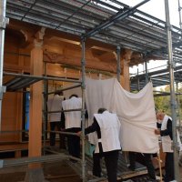 白い布で覆ったご神体を新しい建物内に運び入れる氏子ら
