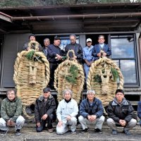 出来上がった三つの大わらじを手に住民が勢ぞろいし、お神酒を注いだ＝５日、富津市