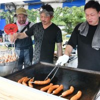町特産の豚肉を使ったフランクフルトを焼く東庄町商工会青年部員＝１１日、同町