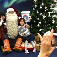 サンタクロースとの記念撮影を楽しむ子どもたち＝成田市の成田空港
