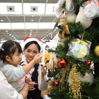 成田空港に登場したクリスマスツリーに飾り付ける園児＝成田市