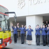 バスでホテルを離れる「最後の宿泊客」を、手を振って見送る従業員たち＝３１日、浦安市の東京ベイ東急ホテル