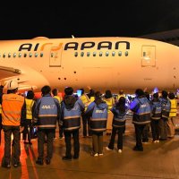 成田空港からバンコクへ就航するエアージャパン旅客機を見送るＡＮＡグループ社員ら＝２月９日、成田市
