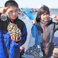 網袋いっぱいになったアサリやハマグリを手に喜ぶ子どもたち＝９日、富津市
