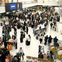 外国人旅客で混み合う成田空港の国際線到着ロビー＝３月２２日、成田市
