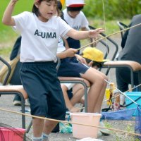 ザリガニを釣り上げ喜ぶ児童