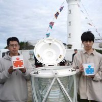 １０年前の１４０周年イベントでタイムカプセルに見立てた灯器に封入したメッセージを手にする高神小出身の代表２人＝１６日、銚子市