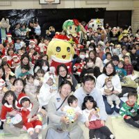 ふなっしーサンタ（中央）を囲み記念撮影する親子連れら＝２５日、船橋市