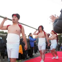 梵天をかついで厳寒の海に向かう下帯姿の若者たち。住民らが拍手で送り出した
