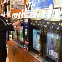 成田山参道に構える滝沢本店で日本酒の試飲サーバーを紹介する滝沢副社長。５００円で最大３種類楽しめる気軽さが外国人観光客らに好評だという＝成田市

