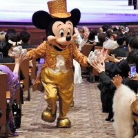 客席に降りたミッキー（中央）を歓迎する「新２０歳」の若者たち＝１３日、浦安市の東京ティズニーシー