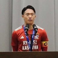 流通経大柏高校で開かれた準優勝報告会であいさつするサッカー部の佐藤主将＝１５日、柏市