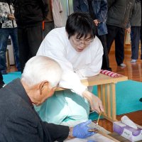 竹筒を割って中身の具合を確認する松山宮司（中央）と地元住民ら＝１５日、匝瑳市