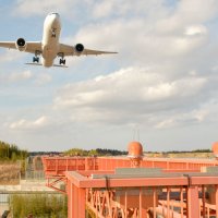 延伸予定のＢ滑走路に向けて着陸態勢に入る航空機。手前の進入灯橋梁の直線に沿って延伸部分が整備される