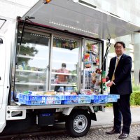 移動スーパーの出発式で商品を持つ月岡町長（左）とマックスバリュ関東の島田社長＝２２日、長柄町役場