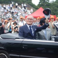 佐倉市の市民栄誉賞表彰式にオープンカーで登場し、帽子を掲げて歓声に応える長嶋茂雄さん＝２０１３年７月１２日、佐倉市の長嶋茂雄記念岩名球場