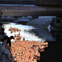 次々と真間川に流される灯籠＝１９日夜、市川市