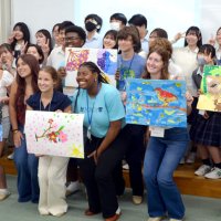 制作したちぎり絵とともに記念写真に納まるモビール市訪問団と市原中央高生徒＝２９日、市原市の市原中央高校