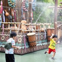 「アドベンチャーランド」前に新設された散水施設で水浴びに夢中の子どもたち
