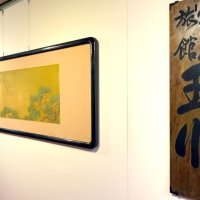 作品展の入り口で来場者を出迎える「玉川旅館」の看板と、日本画家、磯田長秋の「富士図」。「富士図」は旅館の玄関に飾られていたという