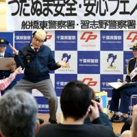 １１０番通報から逮捕までの流れを演じる署員の寸劇を見る角田選手（右）＝イオンモール津田沼