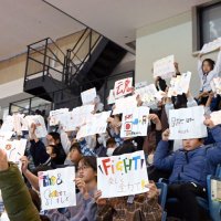 応援メッセージを手に、選手に声援を送る児童